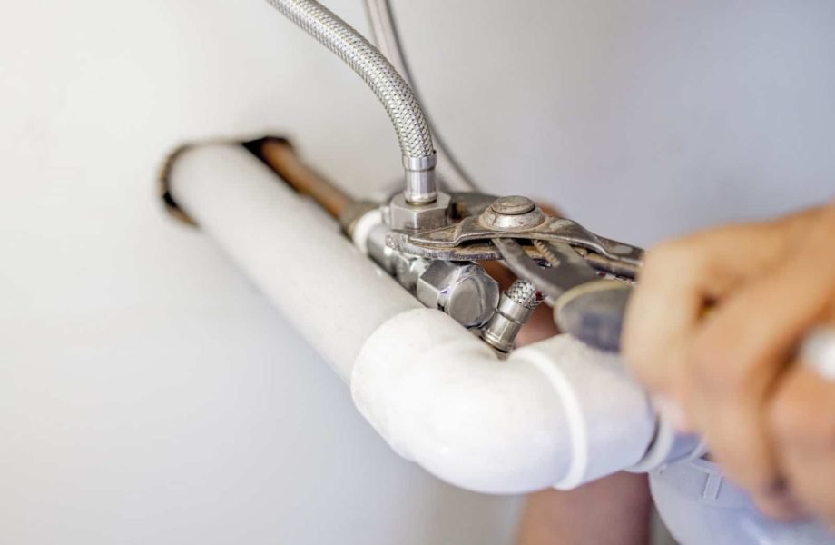 Pipe repair with adjustable wrench in plumbing system, focusing on professional plumbing services an.